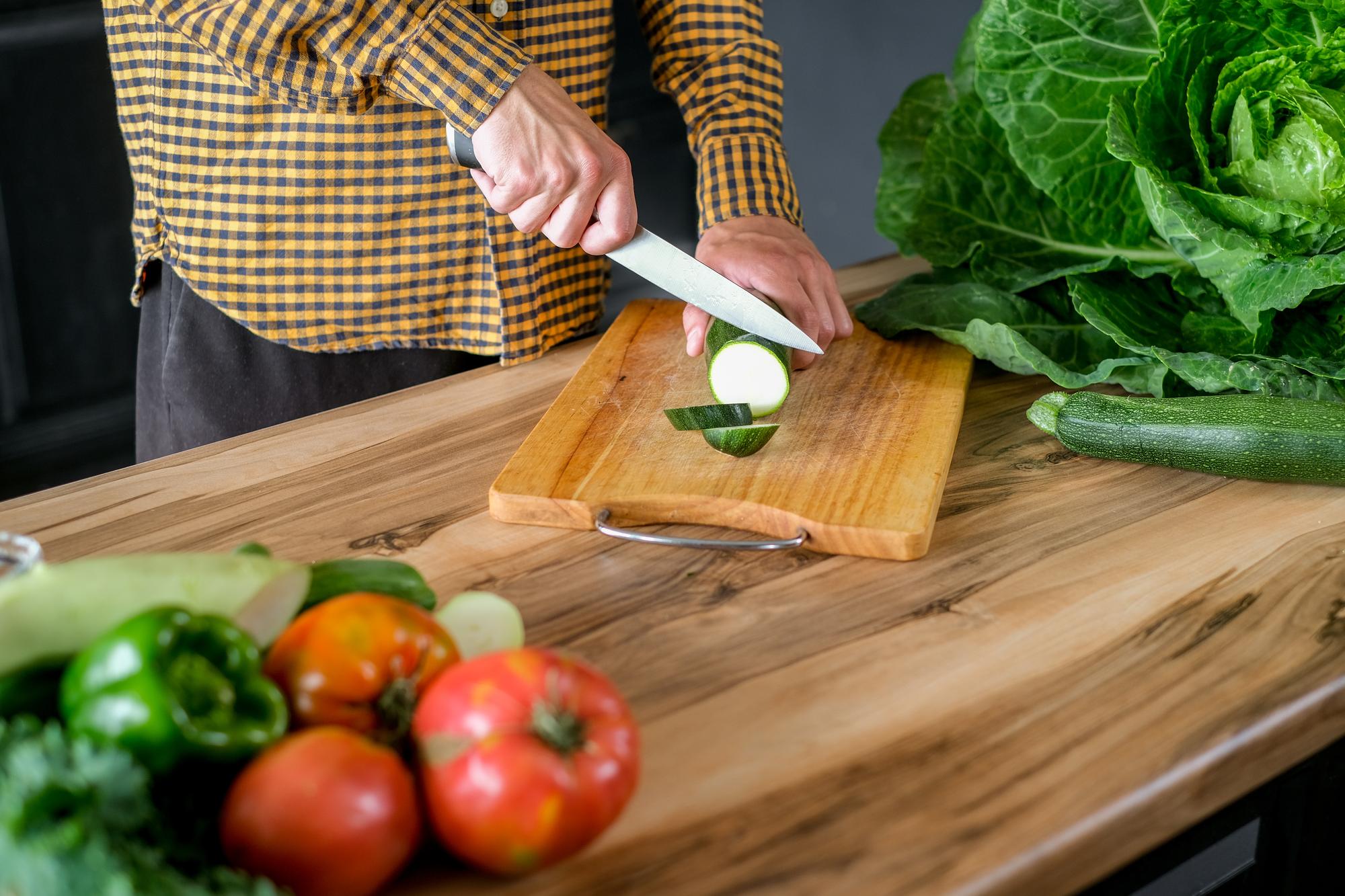 Detalle de manos cortando verduras